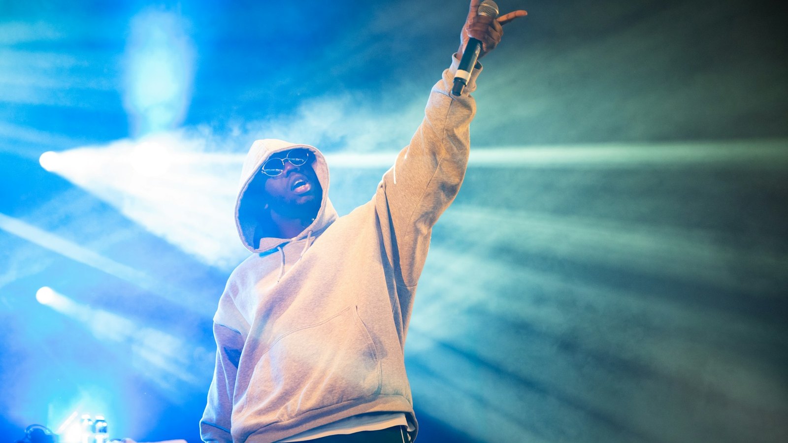 Rapper performing on a stage in front of a crowd