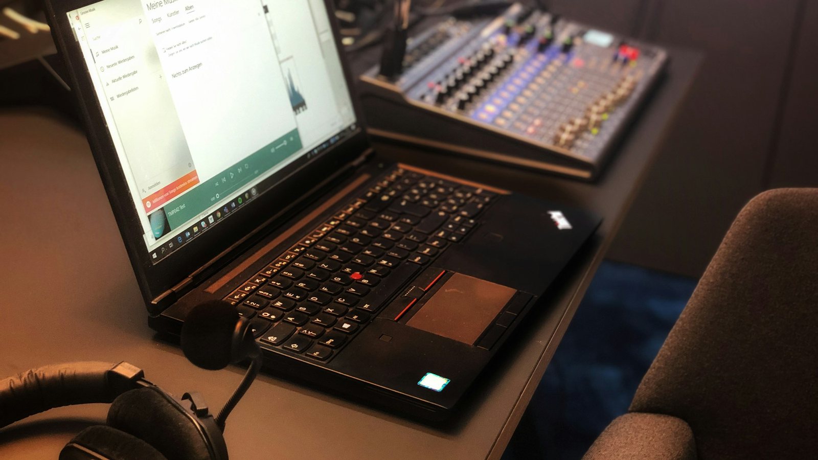 Laptop, headphones and mixing desk in a music studio